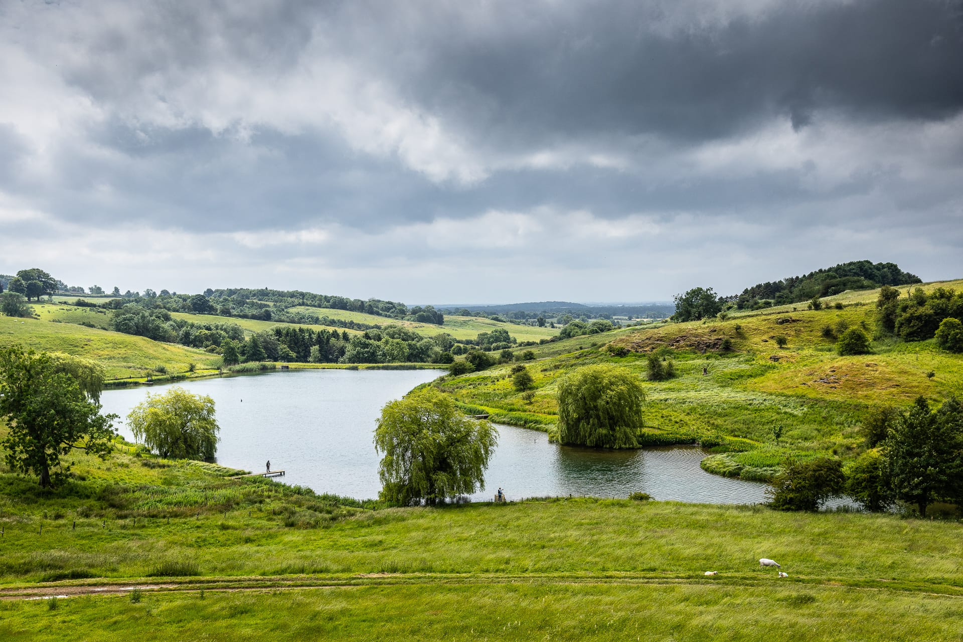View of fishing lake from afar with someone fishing from a fishing dock.