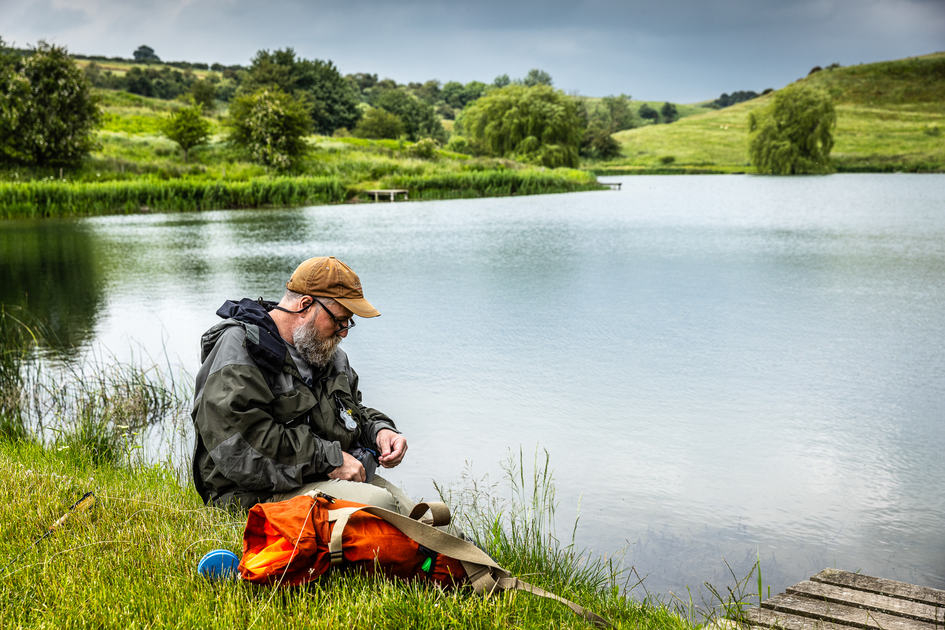 Fisherman baiting his line by the waters edge