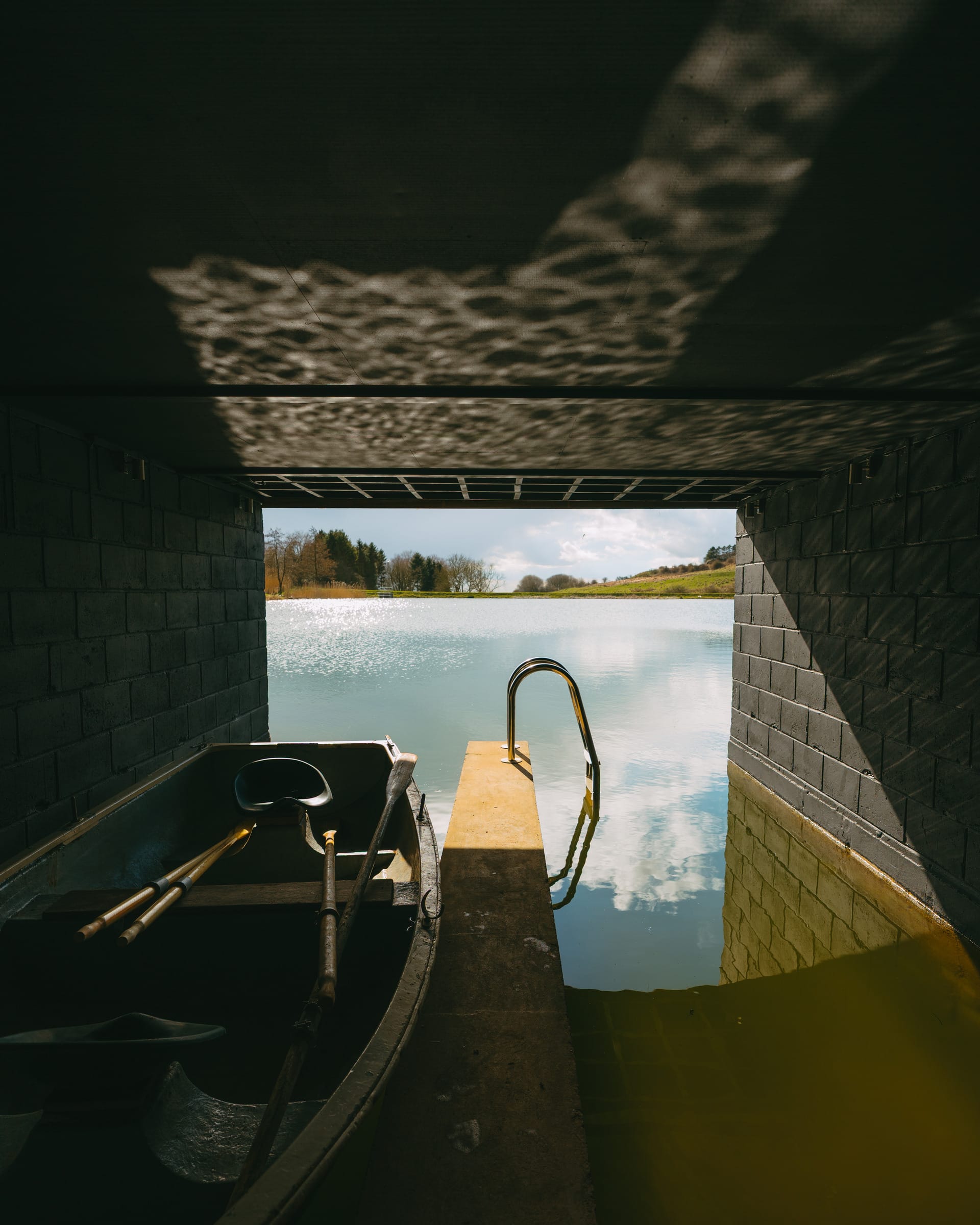 The Otby Boat House dock with a boat and a reflection of the water on the ceiling